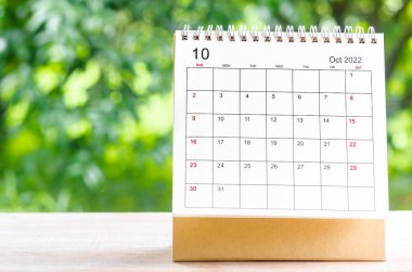 Ekim 2022 Takvim Masası, planlama ve hatırlatma için doğanın arka planındaki ahşap masa üzerine.