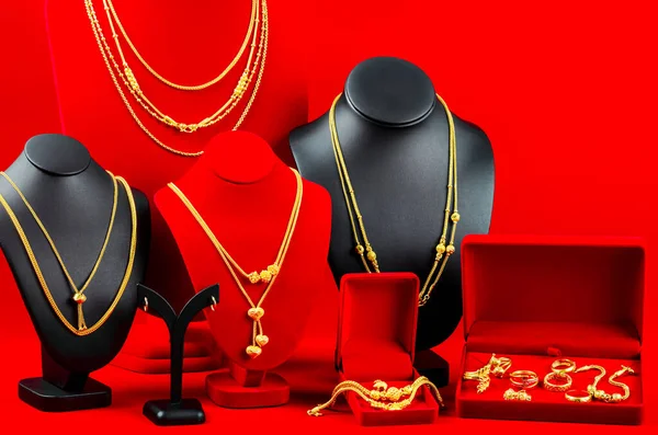 Aksesuar ve altın mücevher gerdanlığı kırmızı kadife kumaş üzerinde altın kolye.