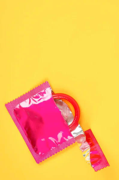 Das Rosa Geöffnete Kondom Und Kondom Packung Auf Gelbem Hintergrund — Stockfoto