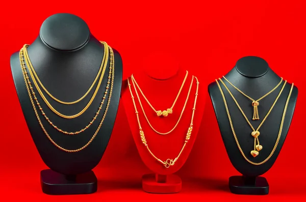 Aksesuar ve altın mücevher gerdanlığı kırmızı kadife kumaşta altın kolye ile sergileniyor..
