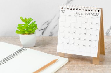 Aralık 2022 masa takvimi. Tahta masa üzerinde bitki var..