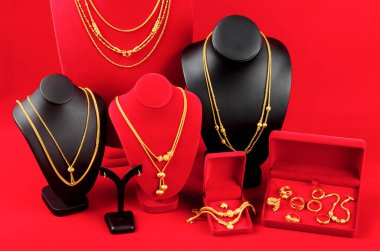 Aksesuar ve altın mücevher gerdanlığı kırmızı kadife kumaşta altın kolye ile sergileniyor..