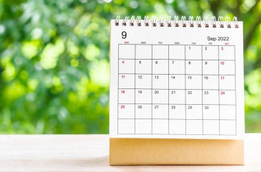 Eylül 2022 Takvim Masası, planlama ve hatırlatma için doğanın arka planındaki ahşap masa üzerine.