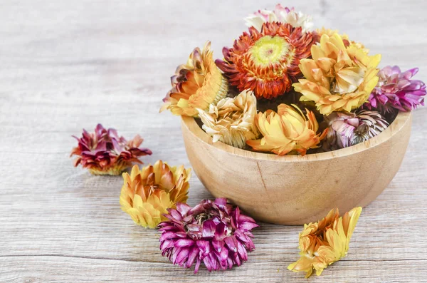 Kurumuş saman çiçeği başları ahşap arka planda ahşap bardakta.
