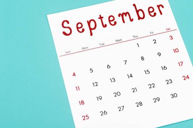 Close up September 2022 calendar sheet on light blue background.