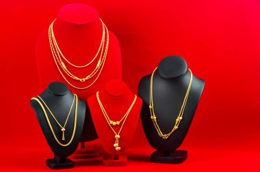 Aksesuar ve altın mücevher gerdanlığı kırmızı kadife kumaşta altın kolye ile sergileniyor..