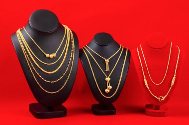 Aksesuar ve altın mücevher gerdanlığı kırmızı kadife kumaşta altın kolye ile sergileniyor..