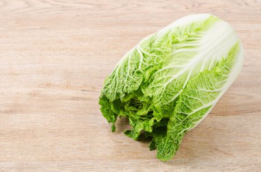 Tahta arka planda beyaz arka planda taze Napa lahanası..