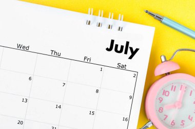 Temmuz 2022 masa takvimi ve sarı zemin üzerinde saksı olan kalem.