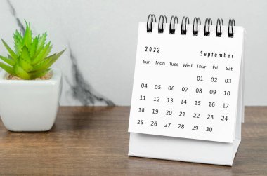 Eylül 2022 masa takvimi. Tahta masa üzerinde saksı var..