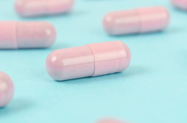 Mavi arka planda Pembe kapsül hapları.