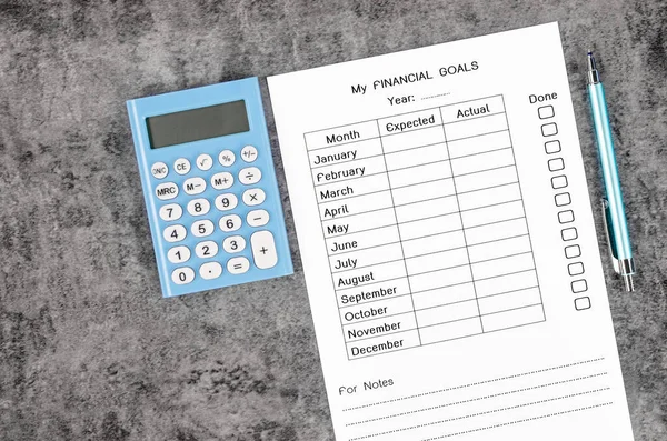 The My planning financial goals form and wooden pen with calculator on wooden background.