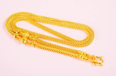 Pembe arka plandaki altın kolye..