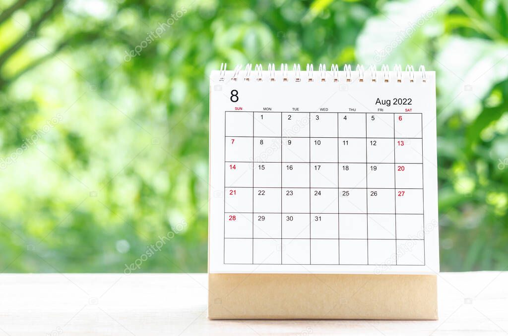 The August 2022 Calendar desk for organizer to plan and reminder on wooden table on nature background.