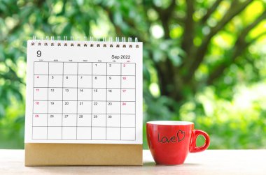 Eylül 2022 Takvim Masası, planlama ve hatırlatma için doğanın arka planındaki ahşap masa üzerine.