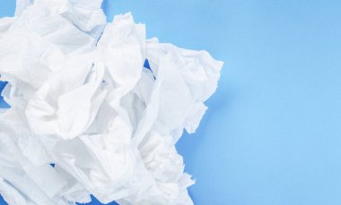 Mavi arka planda buruşmuş kağıt mendil.