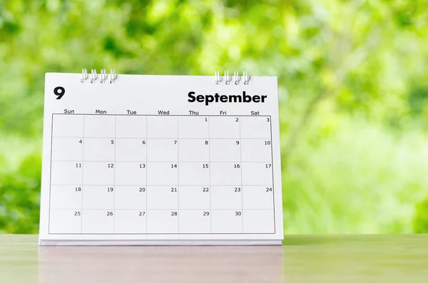 September 2022 Calendar desk for organizer to plan and reminder on wooden table on nature background.