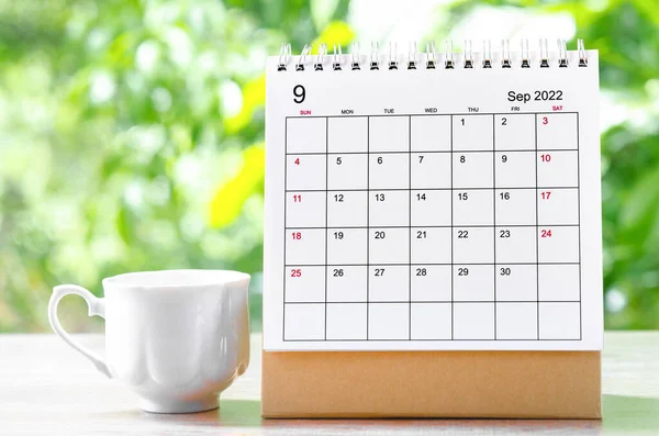 September 2022 Calendar desk for organizer to plan and reminder on wooden table on nature background.