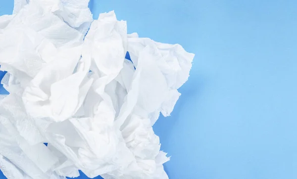 Crumpled tissue paper on blue background.