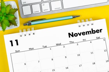 Number 2022 desk calendar with pen and keyboard computer on yellow background.