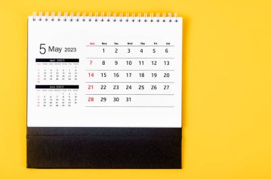 2023 Mayıs ayının masa takvimi sarı arka planda..