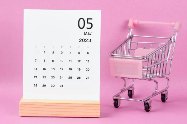2023年5月ピンクを背景にショッピングカートで毎月のカレンダー — ストック写真