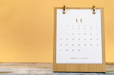 2022 Kasım ayının masa takvimi sarı zemin üzerinde 2022 yıl için.