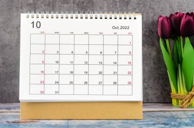 2022 Ekim Masa takvimi ahşap arka planda çiçek ile 2022 yıl.