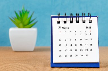 Mart 2023 mavi arkaplan üzerinde takvim platn pot.