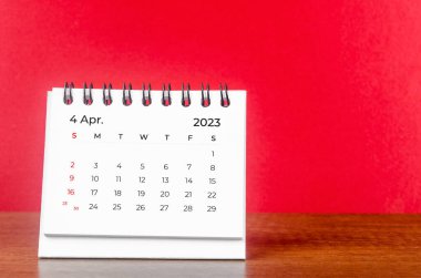 2023 Nisan masa takvimi kırmızı arka planda 2023 yılı.