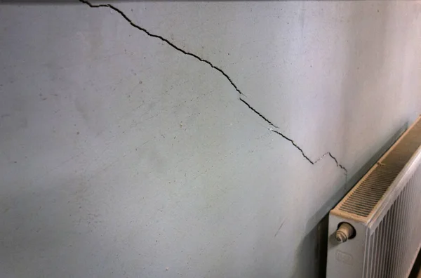 지진 후 벽에 금이 갔어. 집의 벽의 파괴 . 건물의 질낮은 보수. 스톡 사진