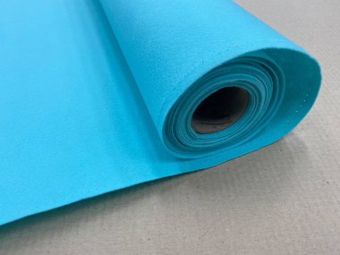 Masada yuvarlak mavi tekstil rulosu. Keçeli kumaş mavi.