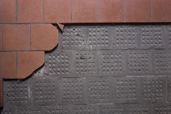 Un muro de hormigón con baldosas caídas. Destrucción de la baldosa en el antiguo taller de la planta. —  Fotos de Stock