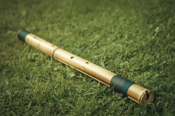 Bamboo flute on the green grass in the garden. Music for meditation and relaxation.