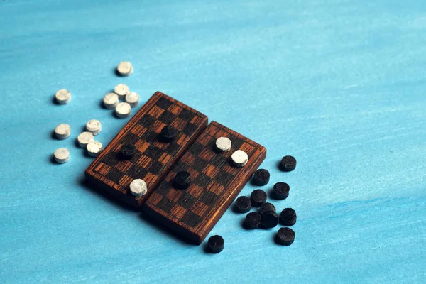 Мініатюрна дошка з шашками на синій ізоляції. саморобні шашки . — стокове фото