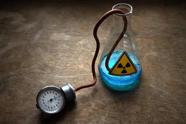유리 실험실 플라스크에 방사성 액체. 파란 액체 병에 방사선 신호. 스톡 사진