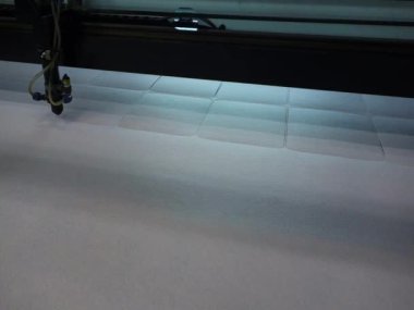 Cutting of textile parts from soft fabric with a laser machine. Production of graphite products.