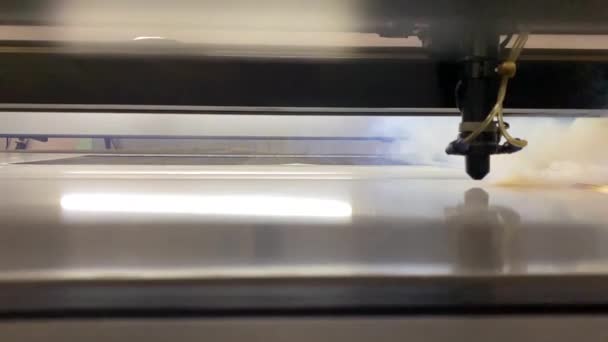 The laser machine cuts plexiglass into parts.When cutting, a poisonous acrid smoke of white color is released. Harmful production. — стоковое видео