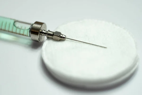 Una jeringa de vidrio con una aguja en un aislado blanco. Vacunación de la población. —  Fotos de Stock