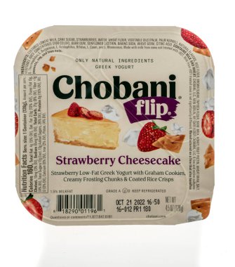 Winneconne, WI - 18 Eylül 2022: Bir paket Chobani, izole edilmiş arka planda çilekli cheesecake Yunan yoğurdu çeviriyor.