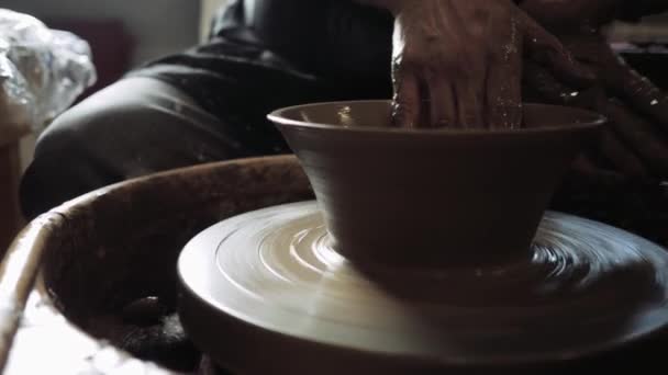 Close-up van het maken van een plaat op een pottenbakkerswiel. — Stockvideo
