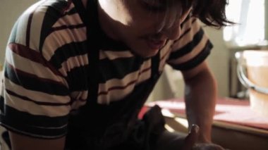 Çalışırken çömlekçiye eğilen erkek çömlekçinin yakın plan yüzü.