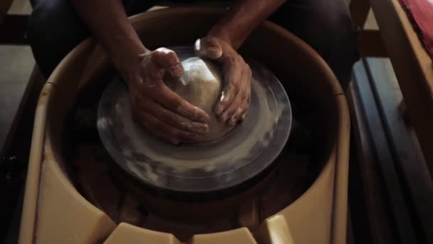Nær hendene på en pottemaker som kneler våt leire på et pottemakerhjul – stockvideo