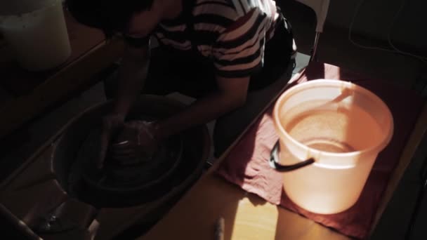 Hrnčíř funguje a vedle něj je kbelík s vodou na smáčení hlíny — Stock video