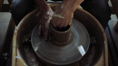 Çömlekçi çarkında çalışan genç bir erkek çömlekçinin elleri.