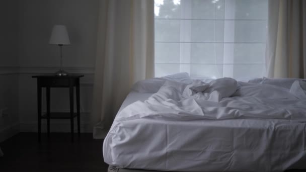 Sebuah kamar tidur cerah dengan tempat tidur dan linen putih. Tempat tidur kosong dengan linen putih. — Stok Video