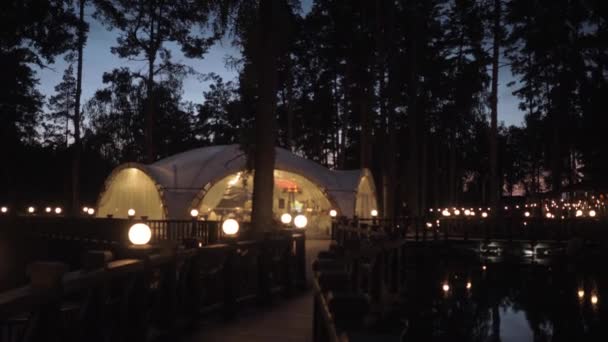 The white tent of the restaurant on a country site at night — Stock video