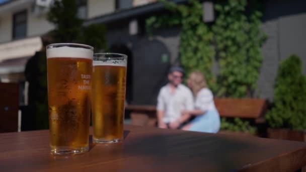 Deux verres de bière sont sur la table sur la véranda extérieure du bar — Video