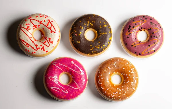 Various coloured doughnuts on a white background — 图库照片