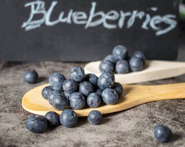 Tahta kaşıklarla servis edilen taze sağlıklı yaban mersinleri.. 